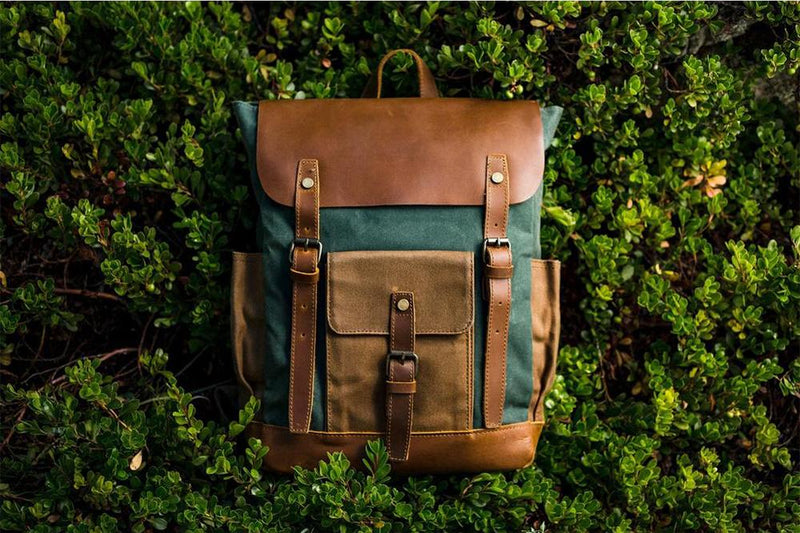 Green Göteborg canvas and leather backpack photographed against foliage
