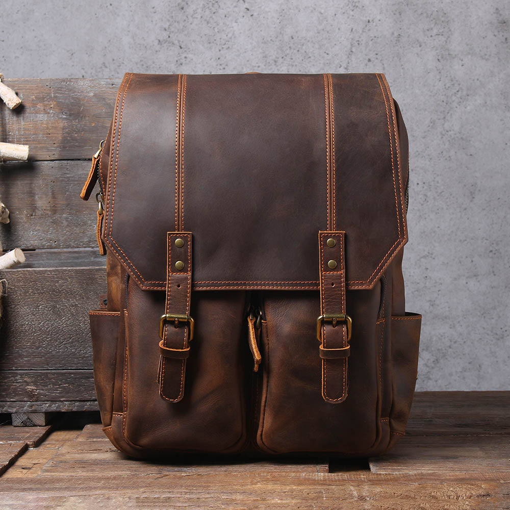 brown full grain leather backpack with contrast orange stitching and antiqued brass roller buckles
