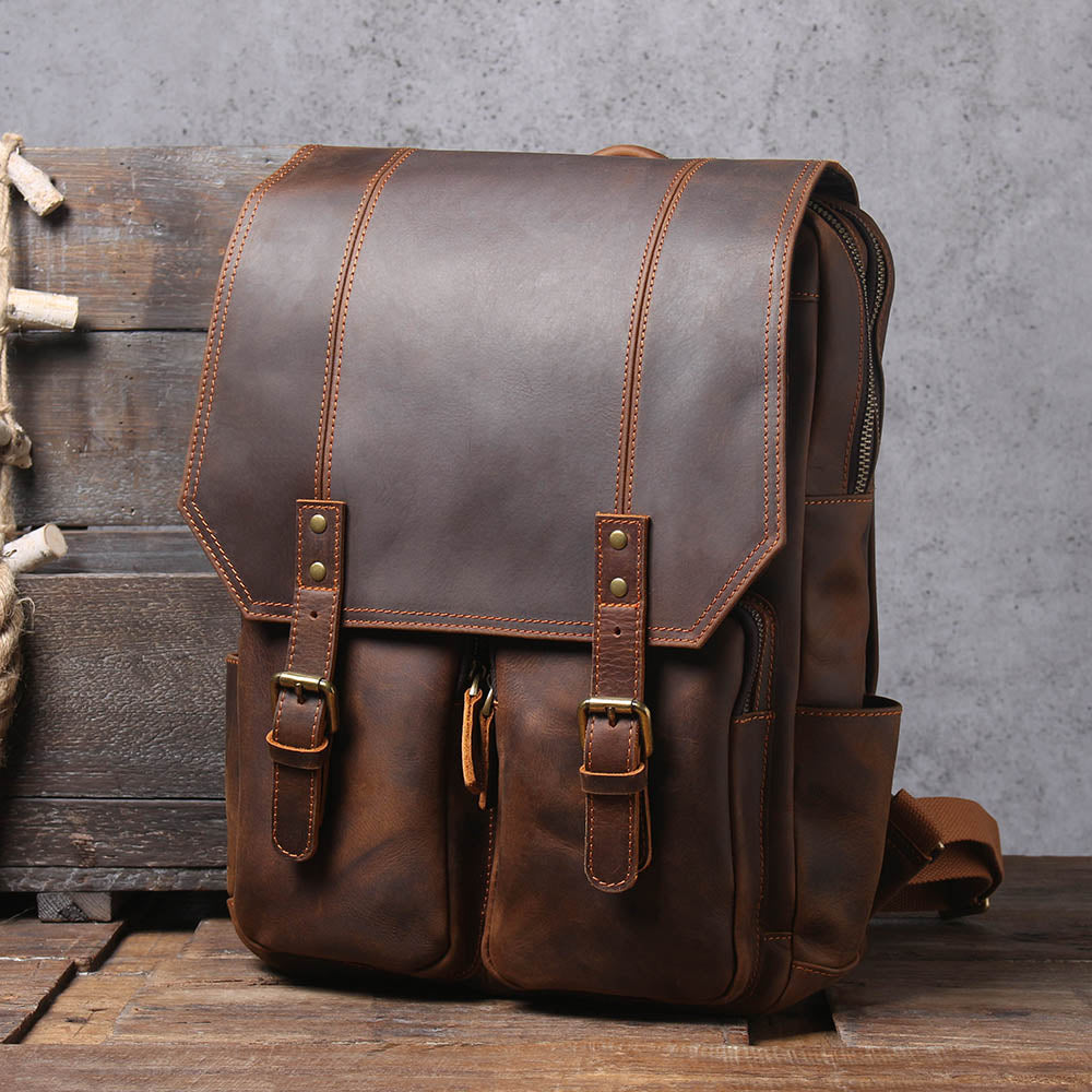 brown leather rucksack in three quarter view showing the side zip and flap stitching