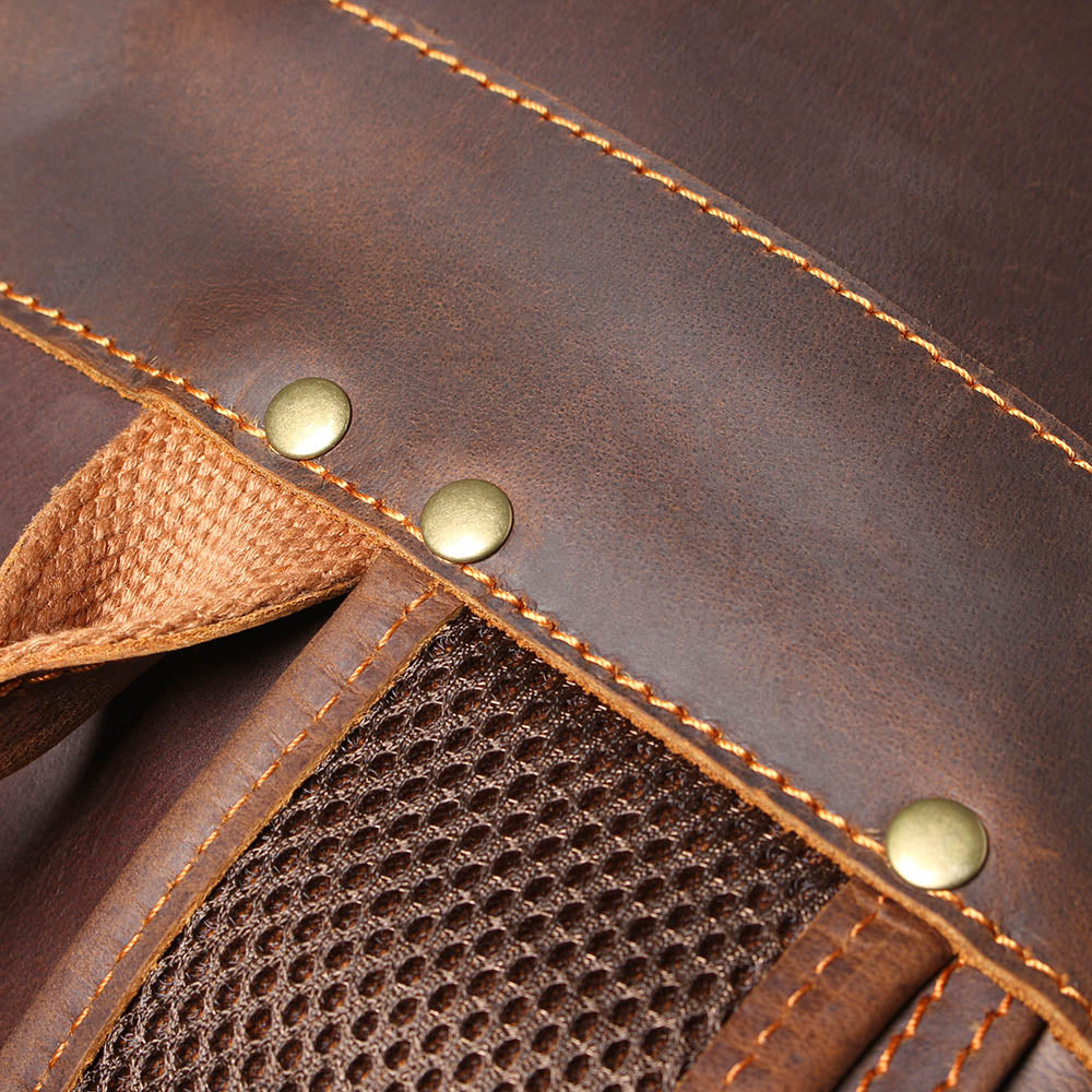 shoulder strap anchor riveted to the leather, mesh backing visible behind