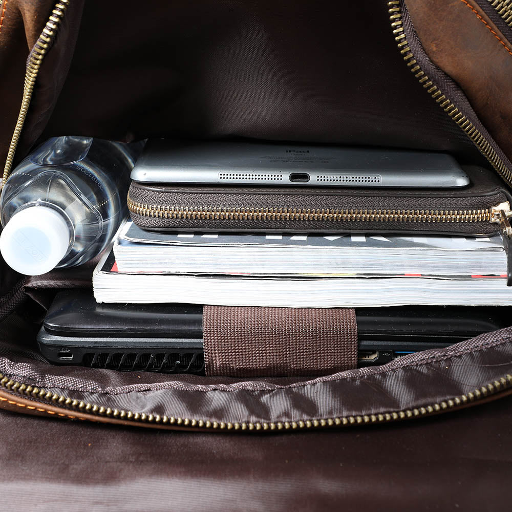 main compartment packed with a laptop, a tablet, magazines and a water bottle