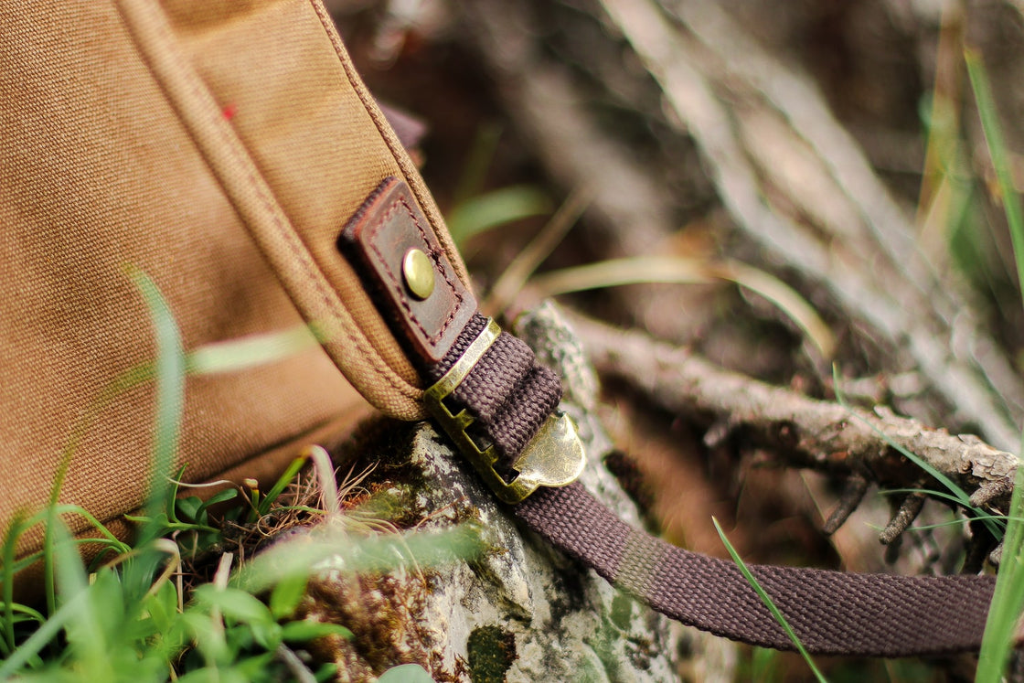 Macro of the cotton webbing shoulder strap anchor with brass rivet on the canvas body of the Calgary rucksack