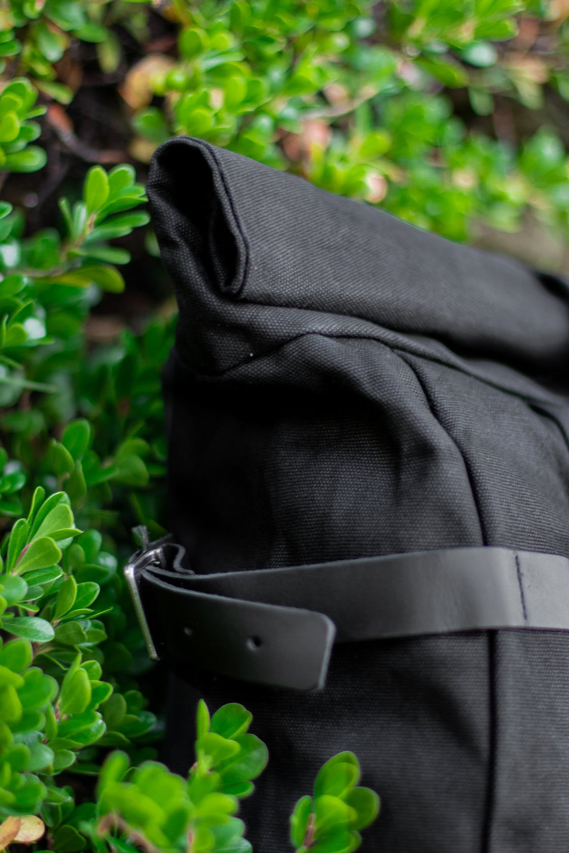Black Gstaad vintage weekender knapsack with rolltop closure, leather strap and brass buckle
