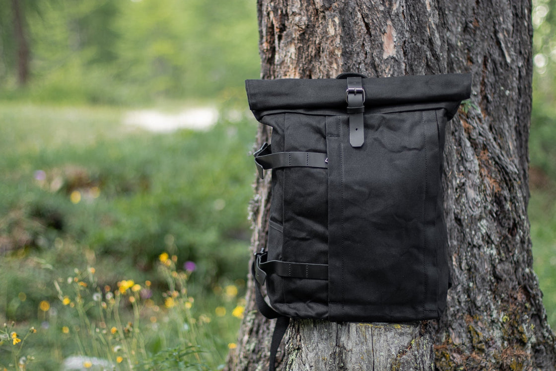 Gstaad noir en toile cirée idéal pour un road trip avec fermeture roll-top et sangle cuir