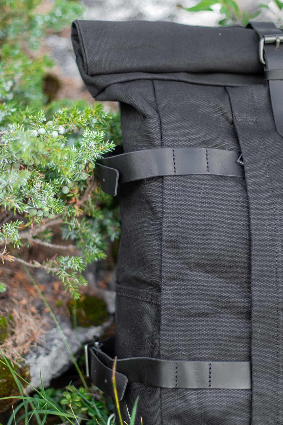 Gstaad noir en sac à dos moto avec sangle en cuir et boucle laiton, fermeture roll-top
