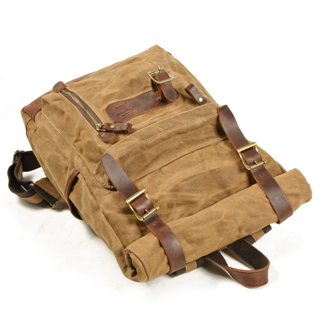 Top-down view of the tan Jersey rugged canvas backpack showing the YKK zip closure, leather magnet flap and twin leather strap closures