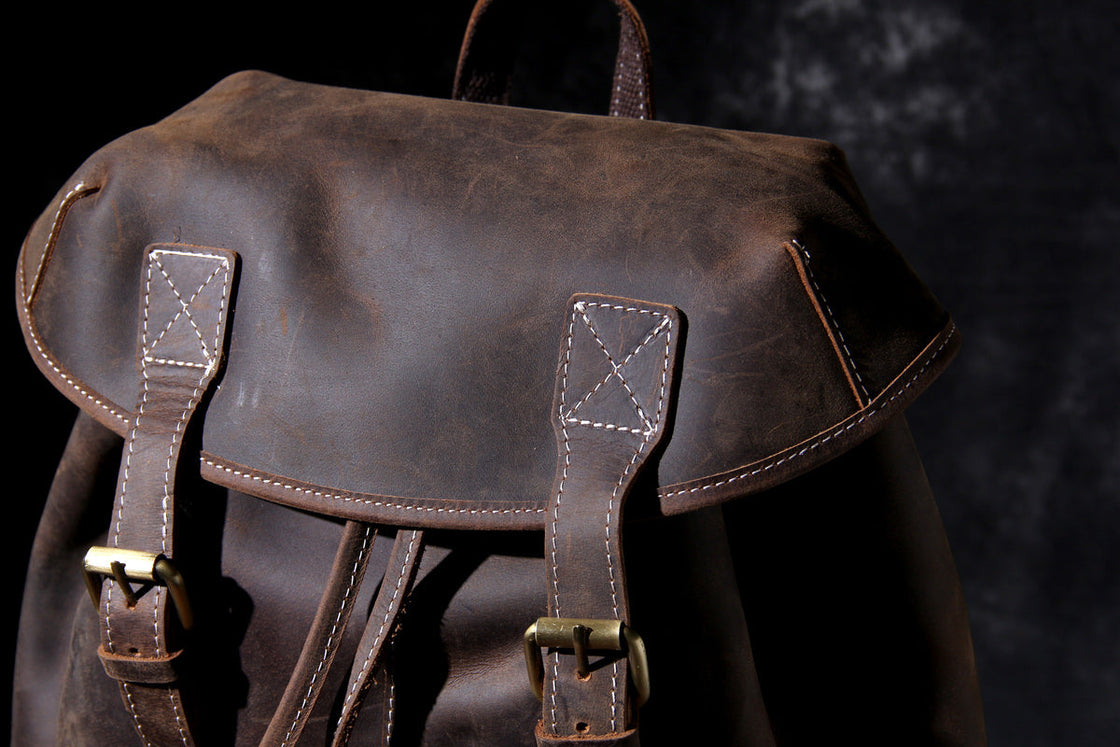 leather day backpack with antique brass roller buckles