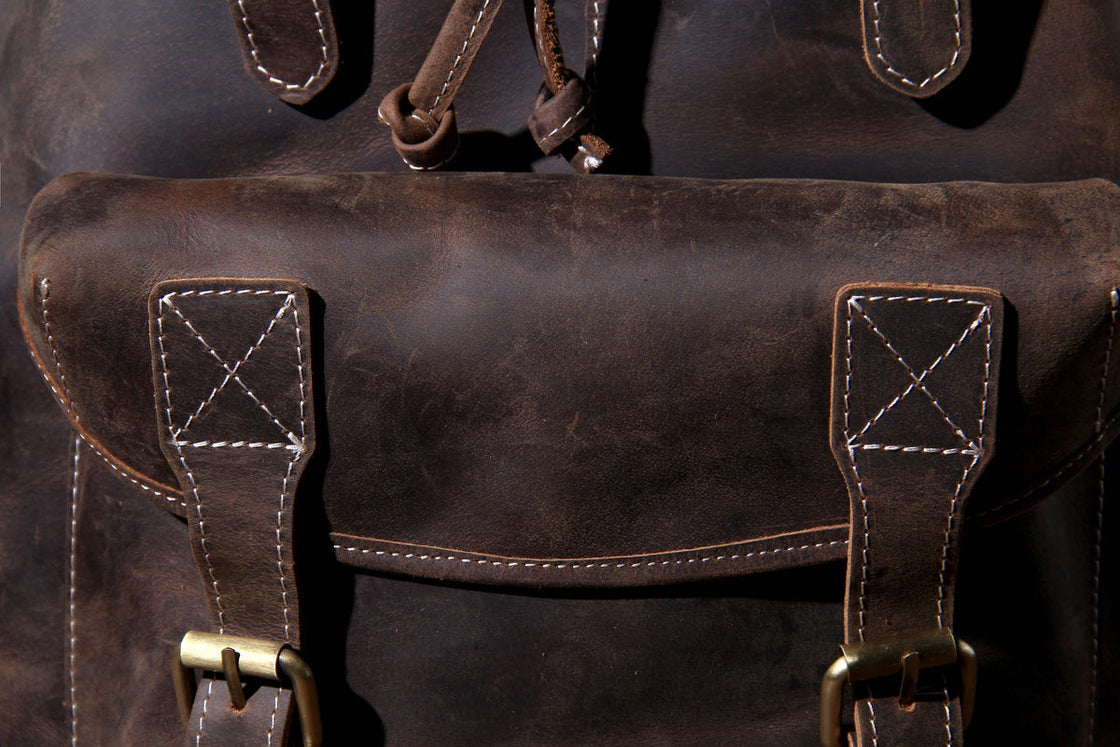 leather rucksack with adjustable leather shoulder straps and buckled flap