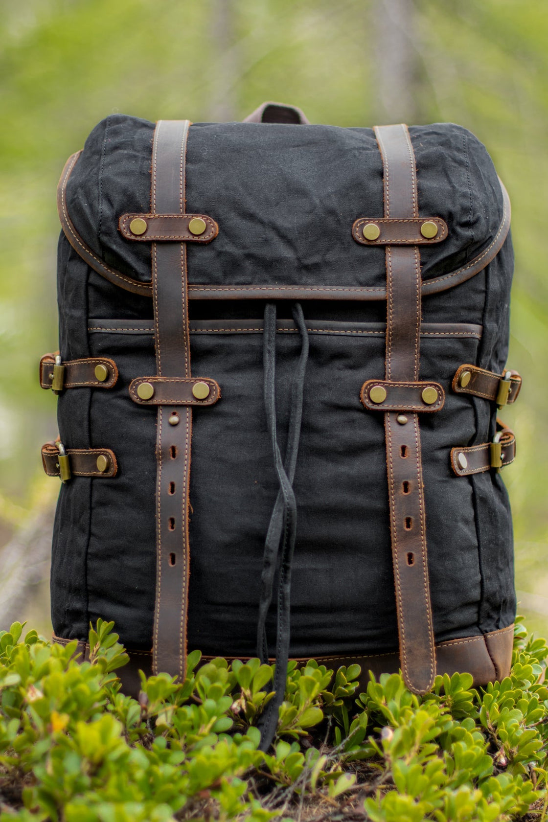 Black Rostock minimalist style satchel with cleaner silhouette, leather strap closures and brass buckle detail