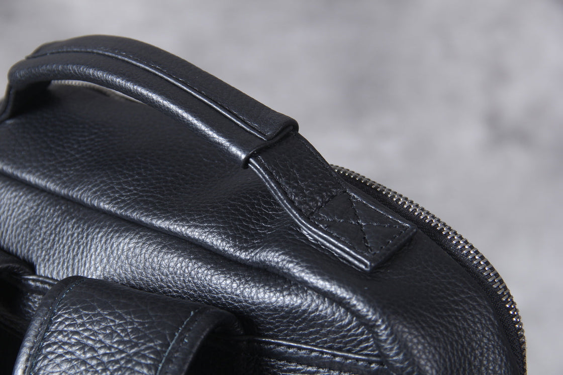 inside the black leather laptop backpack: brown lining, padded laptop sleeve with retaining strap and zipped pocket