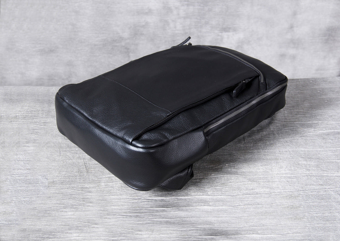 side view of the black leather backpack showing the 10 cm depth and the side zip