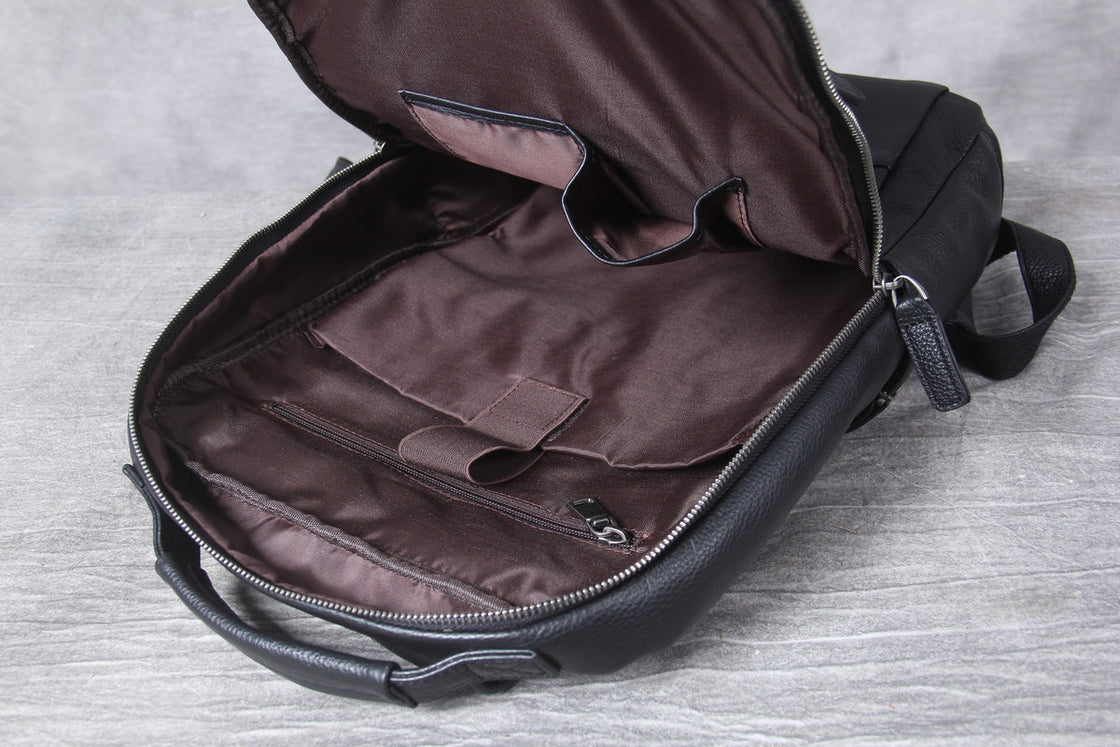cross stitched leather tab anchoring the top handle above the main zip