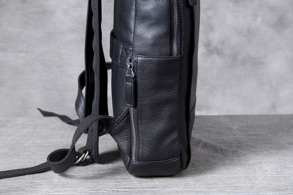 four details of the black leather laptop backpack: zip pulls, handle, side zip and strap adjuster