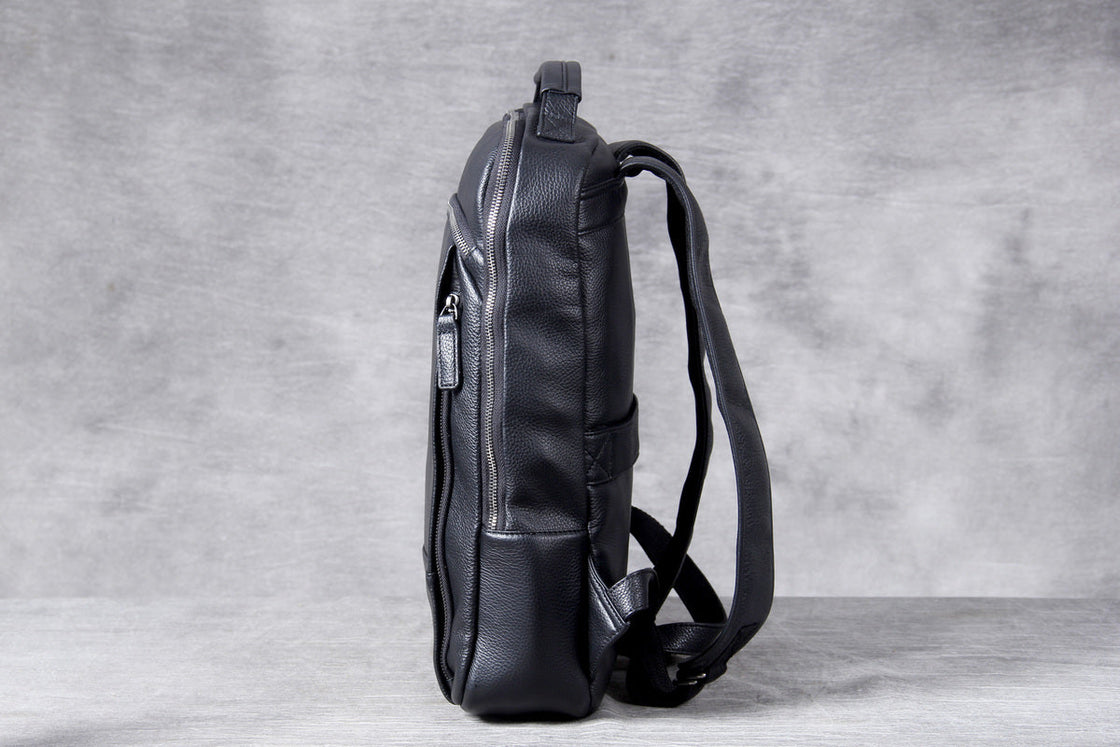 black leather computer backpack worn on the back, three quarter view