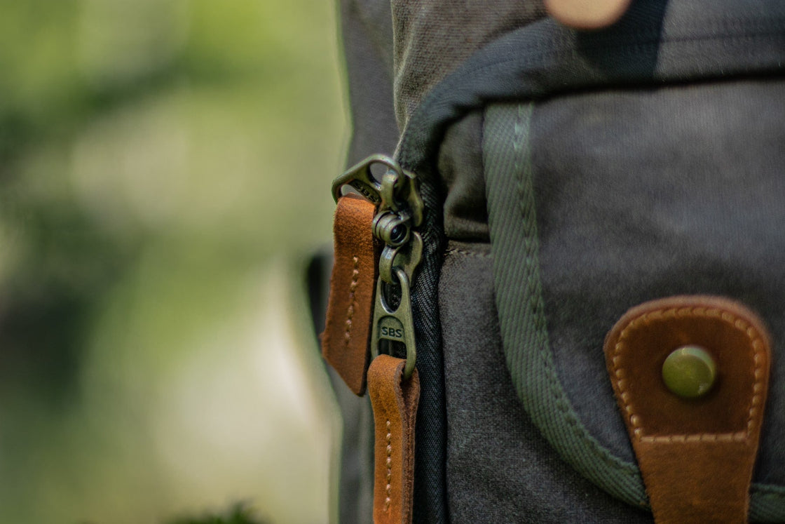Close-up of the SBS zipper and Crazy Horse leather pull tabs on the Vilnius army green camera backpack