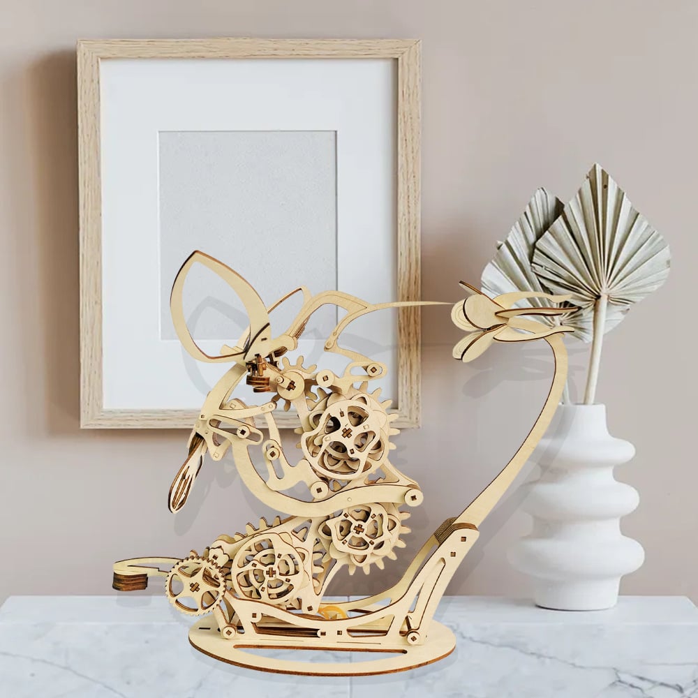 Wooden mechanical bird sculpture on a table with a framed picture Diyion | Kinetic Hummingbird Sculpture - 3D Wooden Mechanical Puzzle Kit