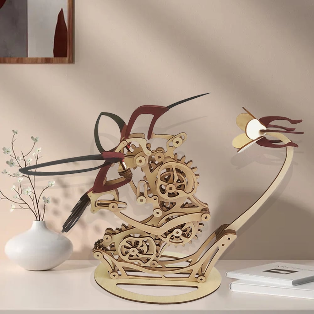 Wooden mechanical model of a dragon on a shelf with a vase and notebook iDiyion | Kinetic Hummingbird Sculpture - 3D Wooden Mechanical Puzzle Kit