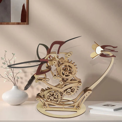 Wooden mechanical model of a dragon on a shelf with a vase and notebook iDiyion | Kinetic Hummingbird Sculpture - 3D Wooden Mechanical Puzzle Kit