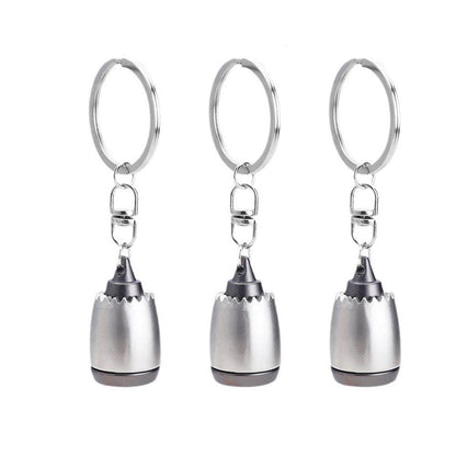 Three silver keychains with a unique design on a white background