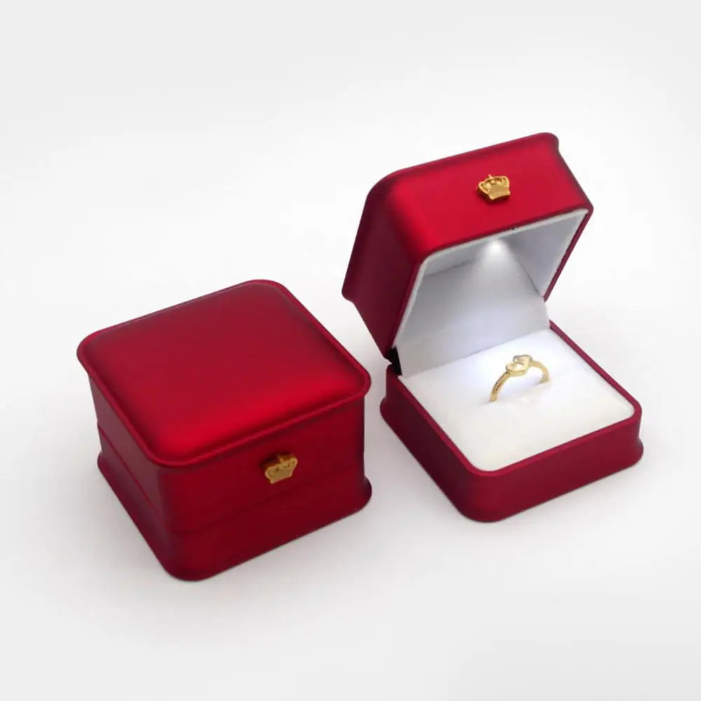 Red jewelry box with a gold ring inside LED ring box with automatic light for engagement proposals and wedding jewelry display