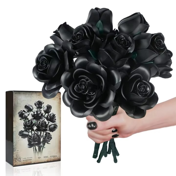 Bouquet of black roses held by a hand with a matching box on a white background