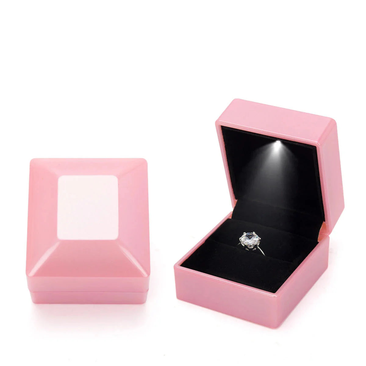 Pink jewelry box with a ring inside on a LED ring box with automatic light for engagement proposals and wedding jewelry display