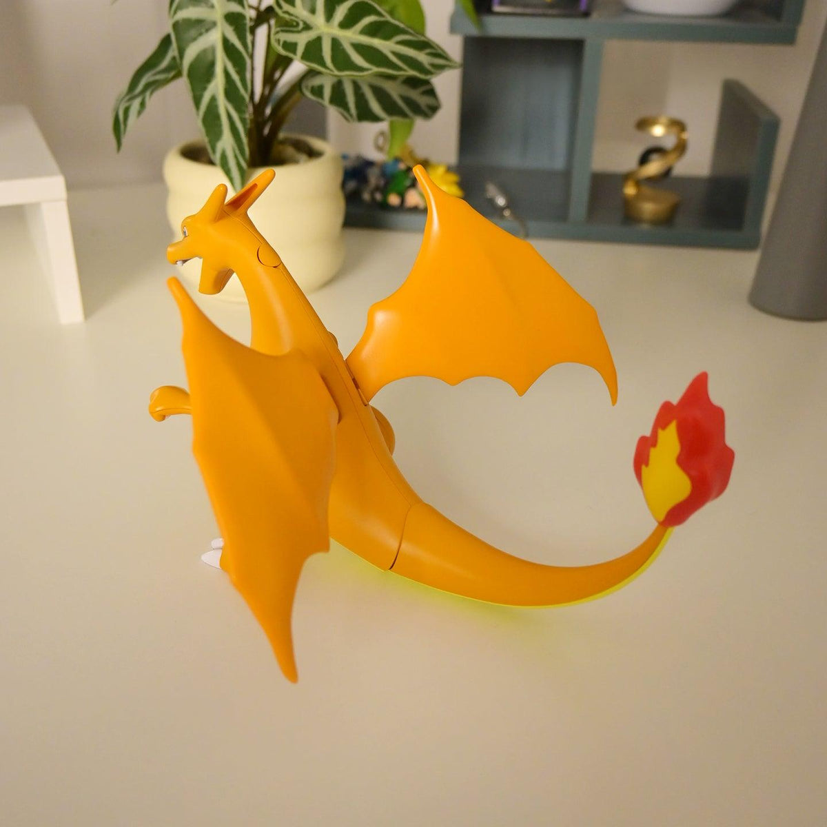 Orange Charizard dragon figure with blue wings and articulated features for shelf display