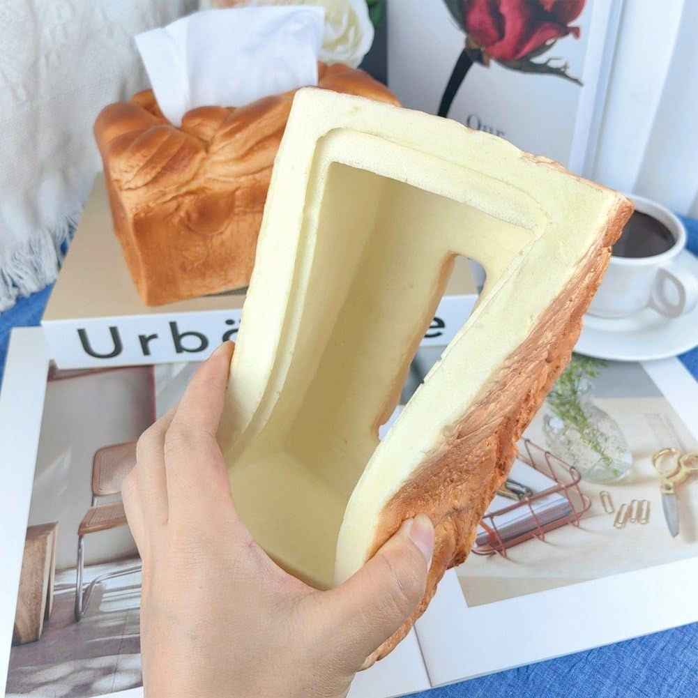 Hand holding a loaf of bread-shaped container with a magazine and coffee cup in the background